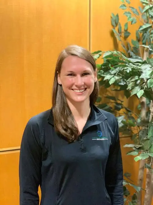 Orthopedist Dr. Cara Beach smiling in a dark gray polo