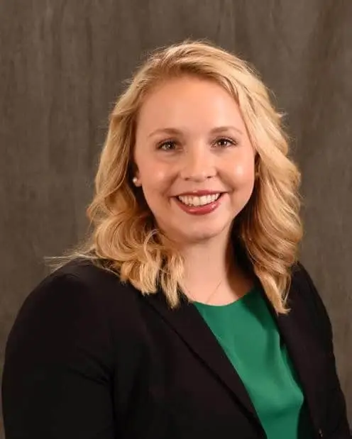 Orthopedist Dr. Lacey Beth Lockhart smiling in a black cardigan and forest green shirt