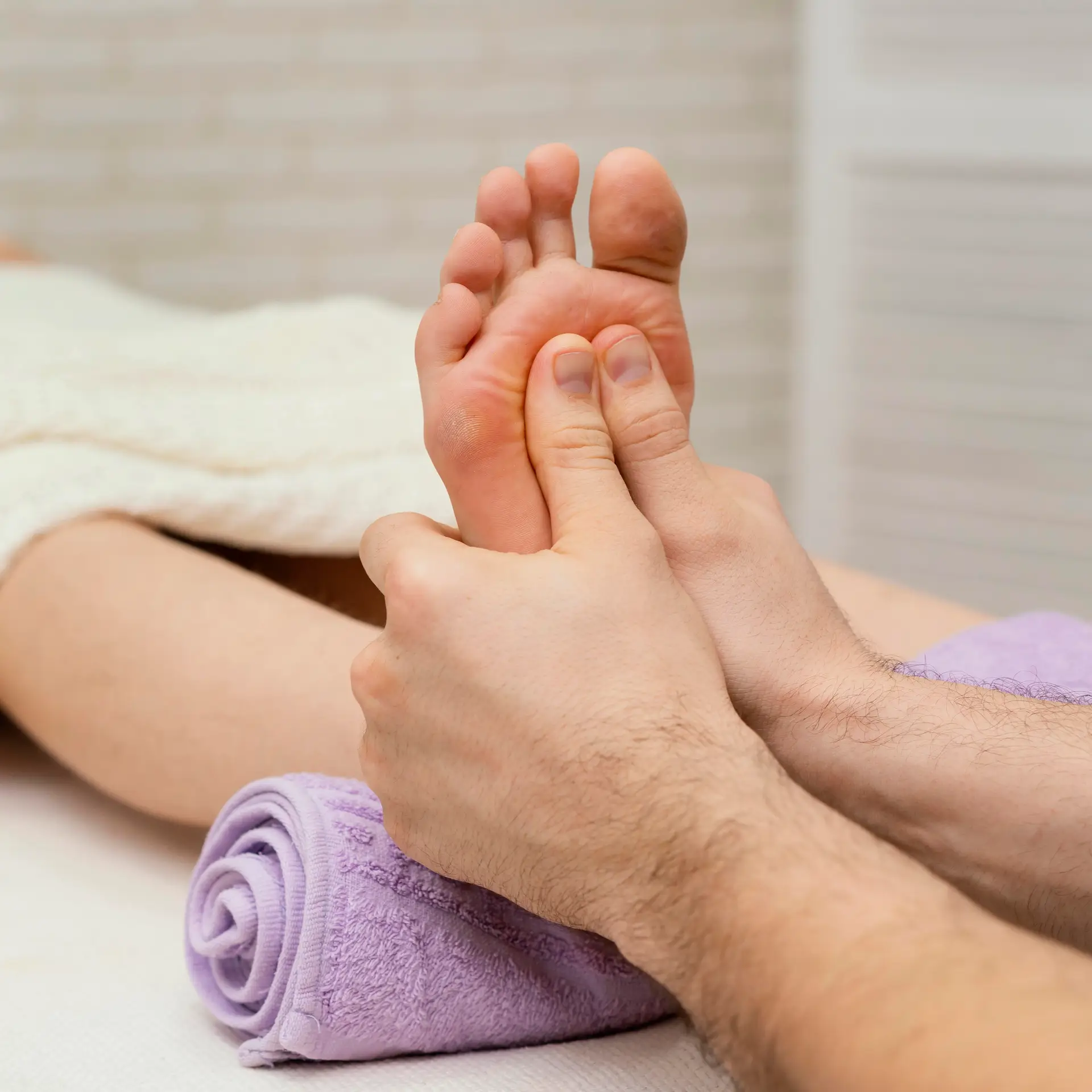 Close-up of hands massaging the sole of a foot during a relaxing foot massage session.